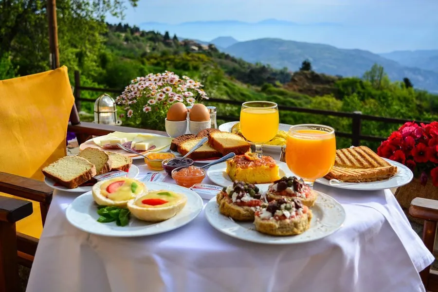 Πρωινό με χυμούς, γλυκά και πίτες στη βεράντα με θέα